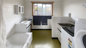 A laundry room with a washing machine, dryer, and a window with a view.