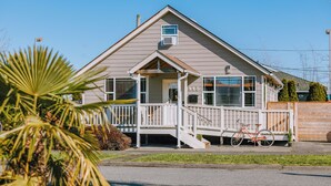 A two-story house with a front porch, a staircase, and a bicycle parked outside. - Mid-Mod Urban Hub | Hot Tub & Fire Pit (Port Angeles)