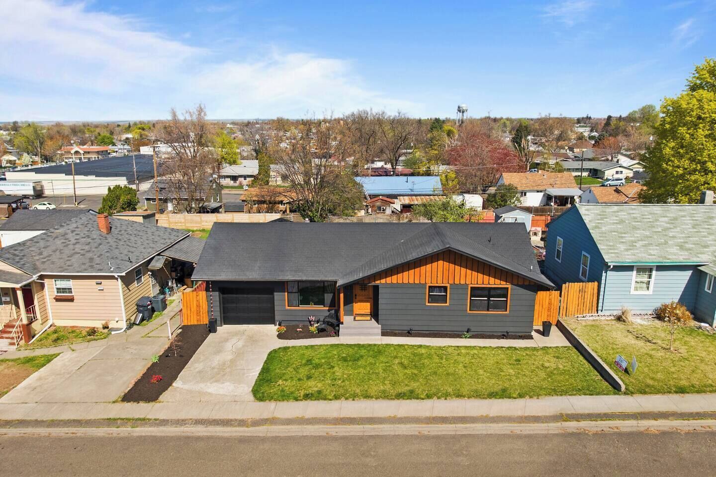 A residential house with a garage, a front yard, and a clear view of the neighborhood.