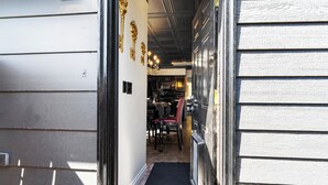 A narrow hallway with a wooden door on the left and a black door on the right. - THE ONYX — A GOTHIC WINE-COUNTRY HOME WITH A HOT TUB, FIRE PIT AND GAME ROO... (College Place)