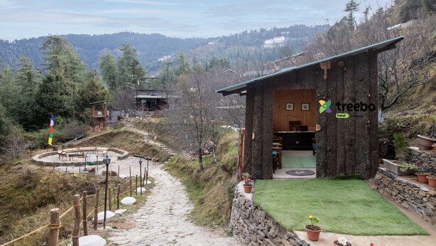 A rustic lodge with a stone exterior, a wooden deck, and a stone pathway leading to the entrance. - Treebo Daak Bangla Retreat With Mountain View (Shimla)