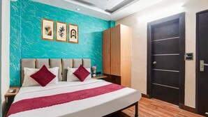 Een hotelkamer met een bed, een kledingkast, een deur en een muur met ingelijste kunstwerken.