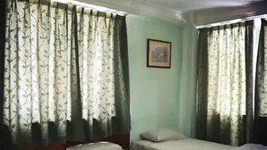 A room with two single beds, each with a pillow and a blanket. There is a framed picture on the wall above the beds. - Hotel O Asia City (Kota Kinabalu)
