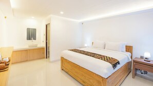 Ein modernes Schlafzimmer mit einem hölzernen Bett, weißen Bettwäsche, einem Nachttisch mit Lampe und einem Badezimmer mit Waschbecken und Spiegel.