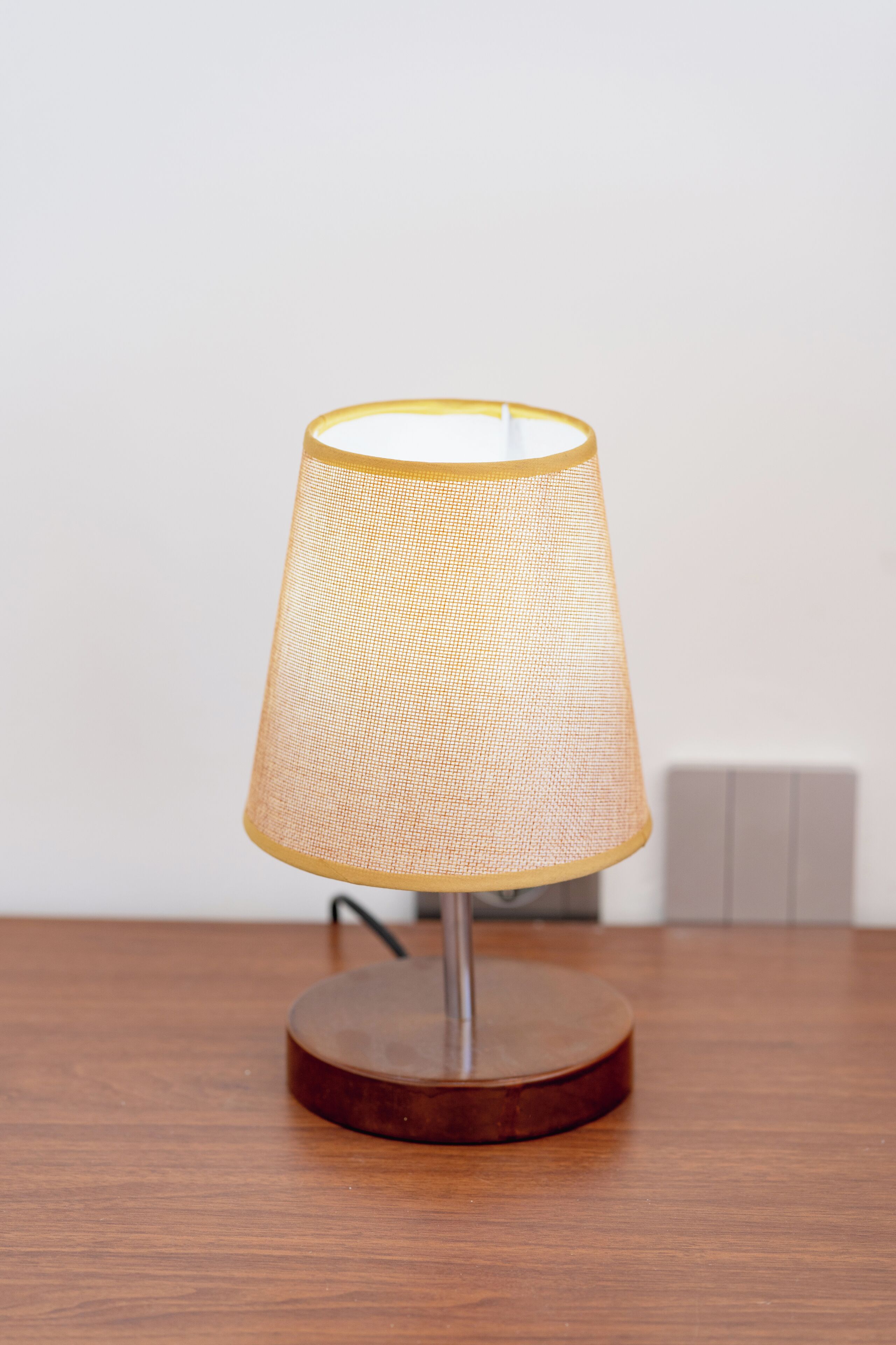 A table lamp with a woven shade and a wooden base.
