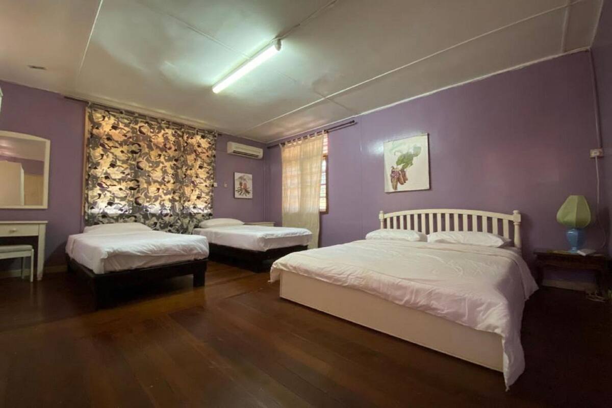 A room with two beds, a desk, and a mirror.