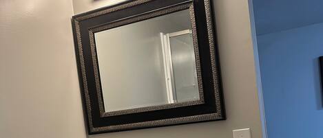 A bathroom with a white sink, a mirror with a decorative frame, and three wall-mounted lights.