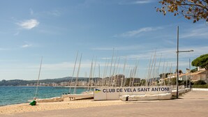 A marina with sailboats docked, a sign for 'CLUB DE VELA SANT ANTONI,' and a paved walkway along the water. - Holiday Apartment "Aubi" with Open Terrace and Indoor Terrace (Palamós)