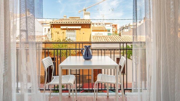 A balcony with a white table, two white chairs, and a blue pitcher. - Holiday Apartment "Aubi" with Open Terrace and Indoor Terrace (Palamós)