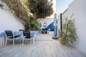 An outdoor patio with a table and chairs, a hanging light fixture, and a potted plant. - BluehousePortixol · Your home by the sea in Palma de Mallorca (Palma)