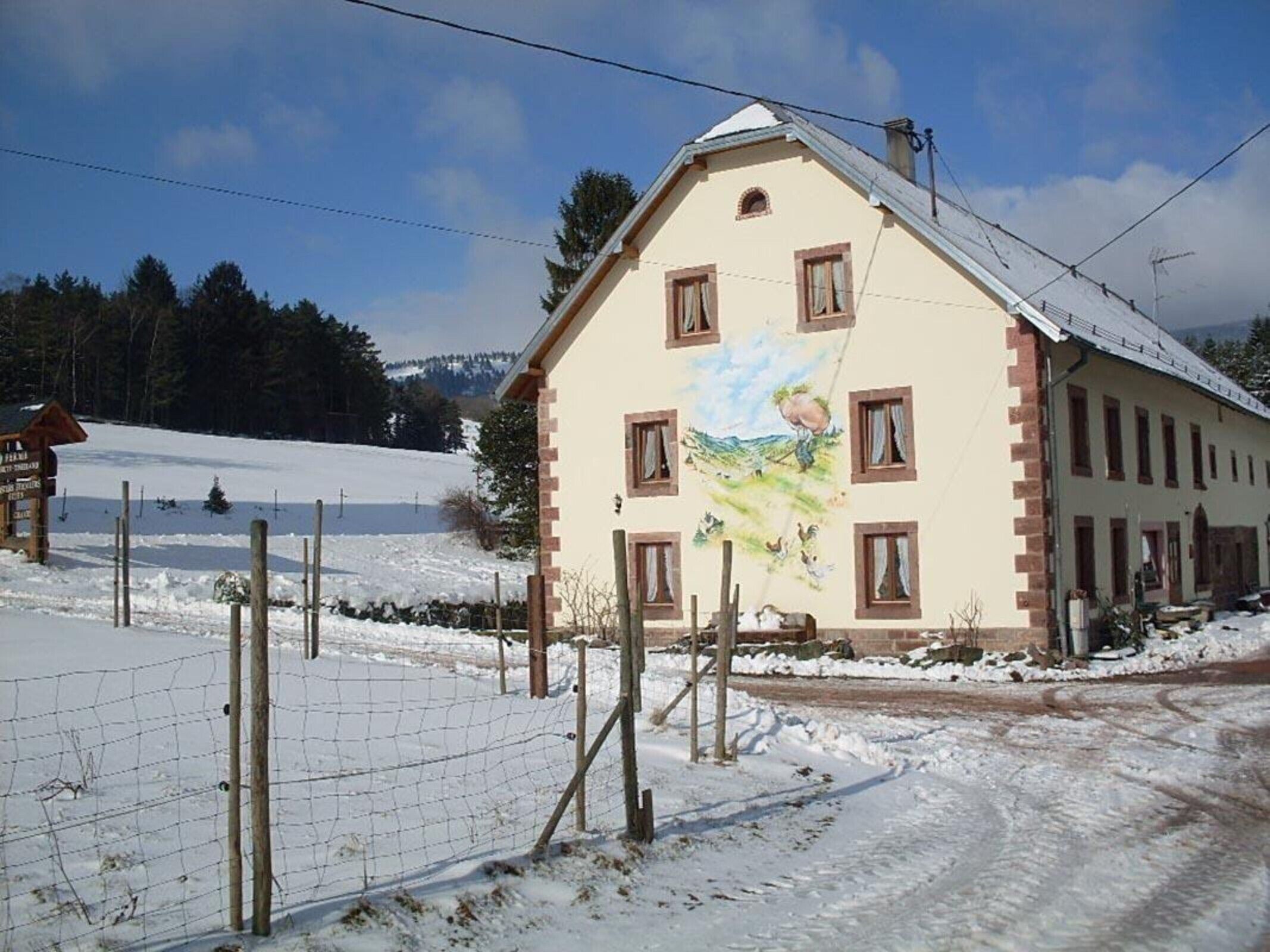 A building with a mural, a snow-covered landscape, and a clear sky.