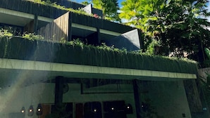 Um edifício moderno com telhado plano, janelas amplas e fachada de concreto.
