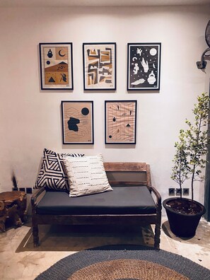 A modern living room with a wooden bench, a patterned throw pillow, and a potted plant. - The CIVYT (Ubud)