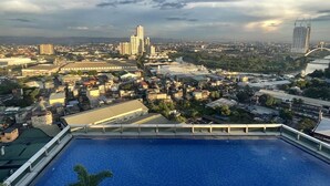 Une piscine sur le toit offrant une vue sur le paysage urbain, avec notamment des gratte-ciel et un pont.