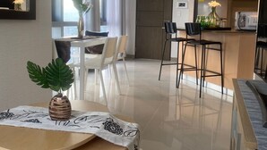 Un salon moderne comprenant un coin repas, une cuisine et une grande fenêtre.