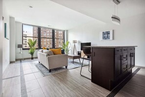 A modern living room with a sofa, coffee table, and a dark wooden cabinet. - 2BR Premium Downtown Suite (Detroit)