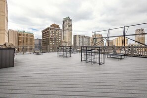 A rooftop terrace with metal furniture and a view of city buildings. - 2BR Executive Downtown Retreat (Detroit)