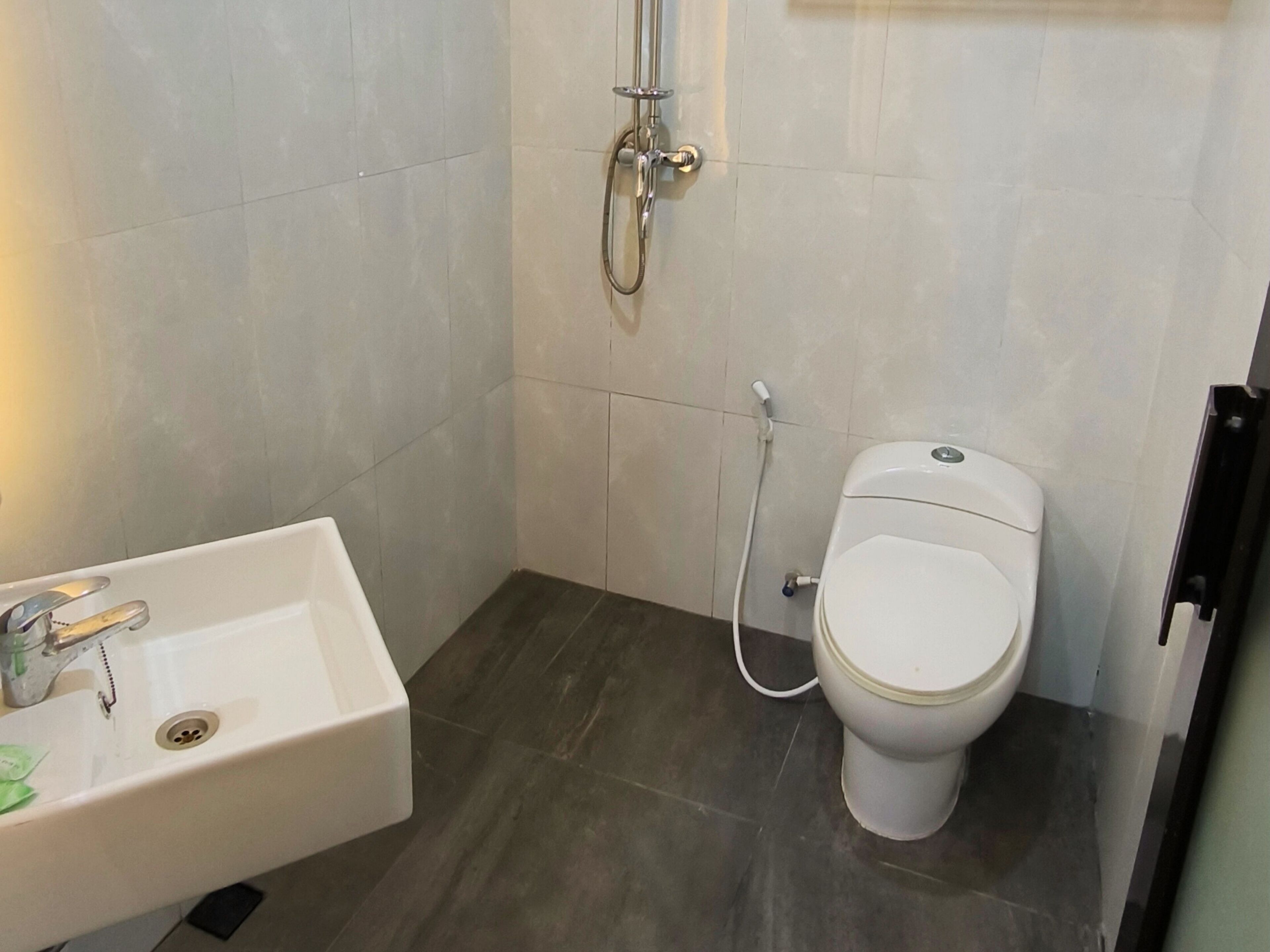 Un baño pequeño con un lavamanos blanco, inodoro y ducha.