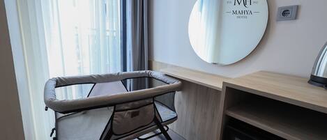 Quarto de hotel moderno com um espelho grande, uma escrivaninha e uma poltrona acolchoada.