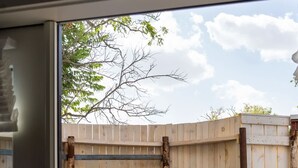 A hot tub in an outdoor setting with a wooden fence and a towel hanging on a hook. - Cozy Suite with Hot Tub in Fredericksburg (Fredericksburg)