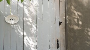 A white wooden door with a metal handle and a round plaque with the number 6. - Cozy Suite with Hot Tub in Fredericksburg (Fredericksburg)
