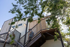A multi-level building with a staircase, metal railings, and a wooden deck. - Cozy Suite with Hot Tub in Fredericksburg (Fredericksburg)