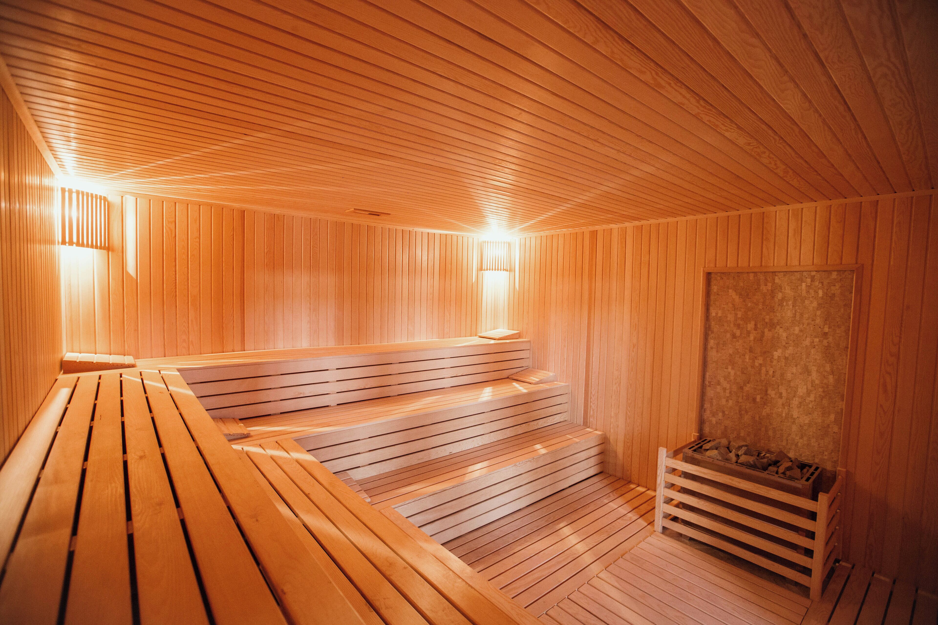 Eine Sauna mit Holzbänken und einer Bank am Ende des Raumes.