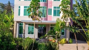 A multi-story hotel with a modern architectural design, featuring a central atrium and large windows. - Elanacha Hotel (Arusha)