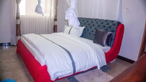 A bedroom with a bed, curtains, and a window. - Elanacha Hotel (Arusha)
