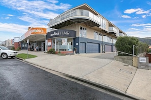 A modern building with a storefront for 'mod-ish HAIR' and a 'FINDWORKS' sign.