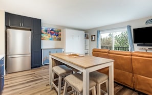Cozy living space with a kitchenette, dining table, and comfortable sofa.