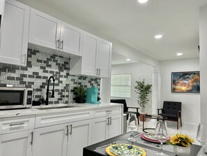Enjoy meals in the kitchen with appliances and a dining area featuring a glass table.