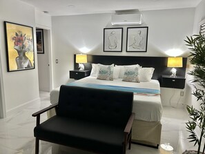 Relax in a serene space with a neatly made bed, bedside tables, and a large window offering a view.