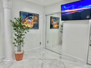 Enjoy a sophisticated ambiance with a flat-screen TV, abstract art, and a natural touch from a bamboo plant.