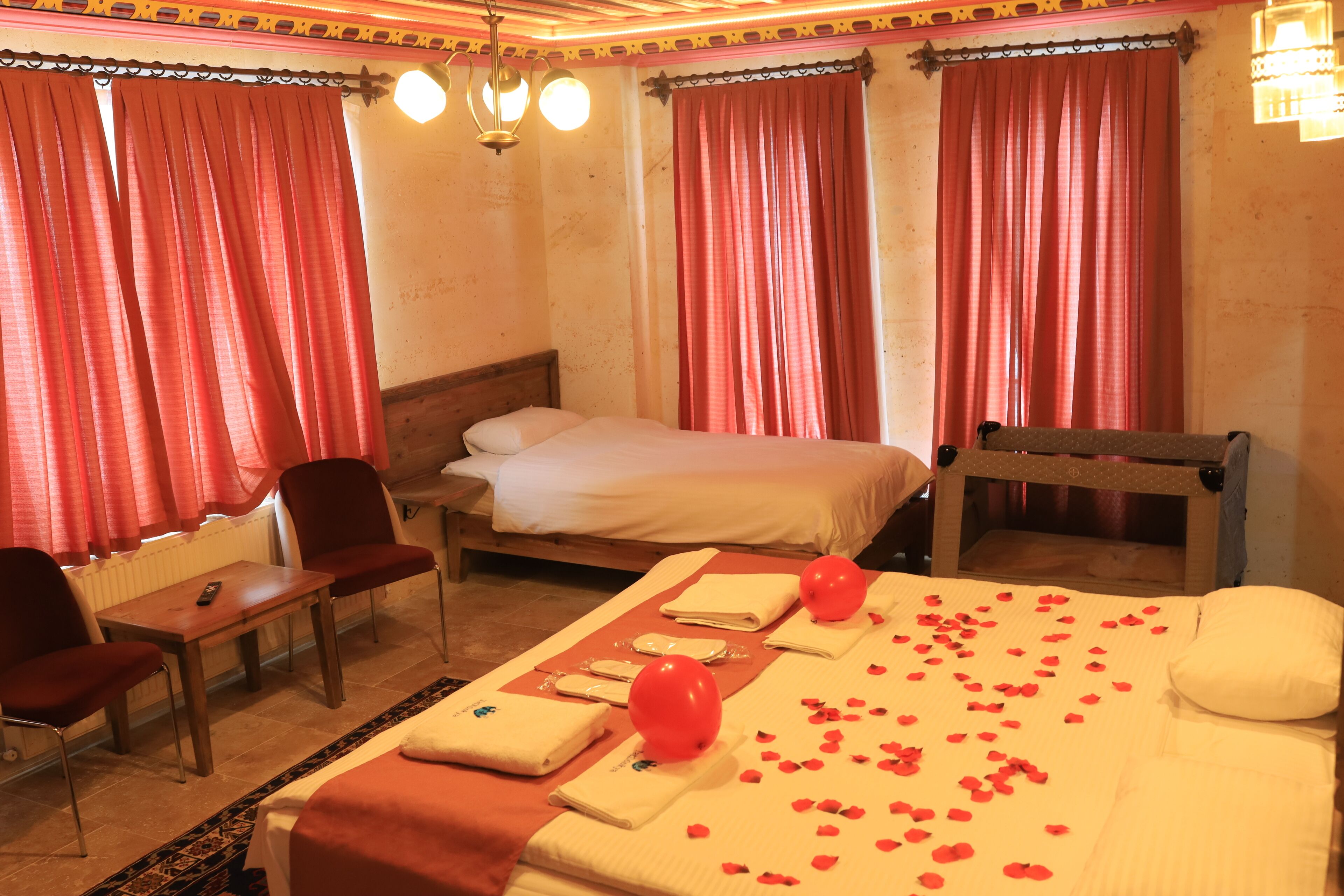 A hotel room with a bed, a chair, a table, and a massage table.