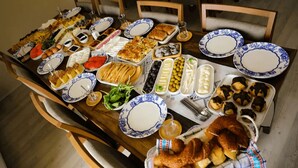 Una tavola imbandita con diversi piatti, tra cui pane, insalate e dolci.