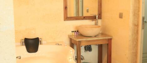 Un baño con bañera, lavabo y espejo.