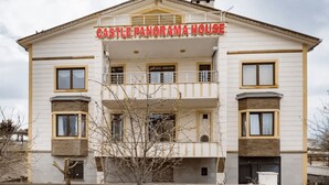 Un edificio a più piani con un cartello che riporta la scritta "CASTLE PANORAMA HOUSE".
