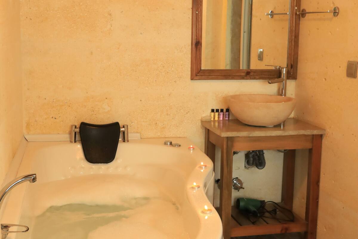 A bathroom with a bathtub, a sink, and a mirror.