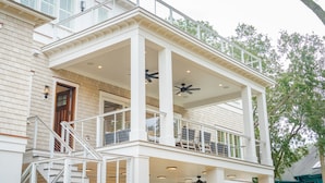 Una casa a due piani con un balcone, una scala e una porta.