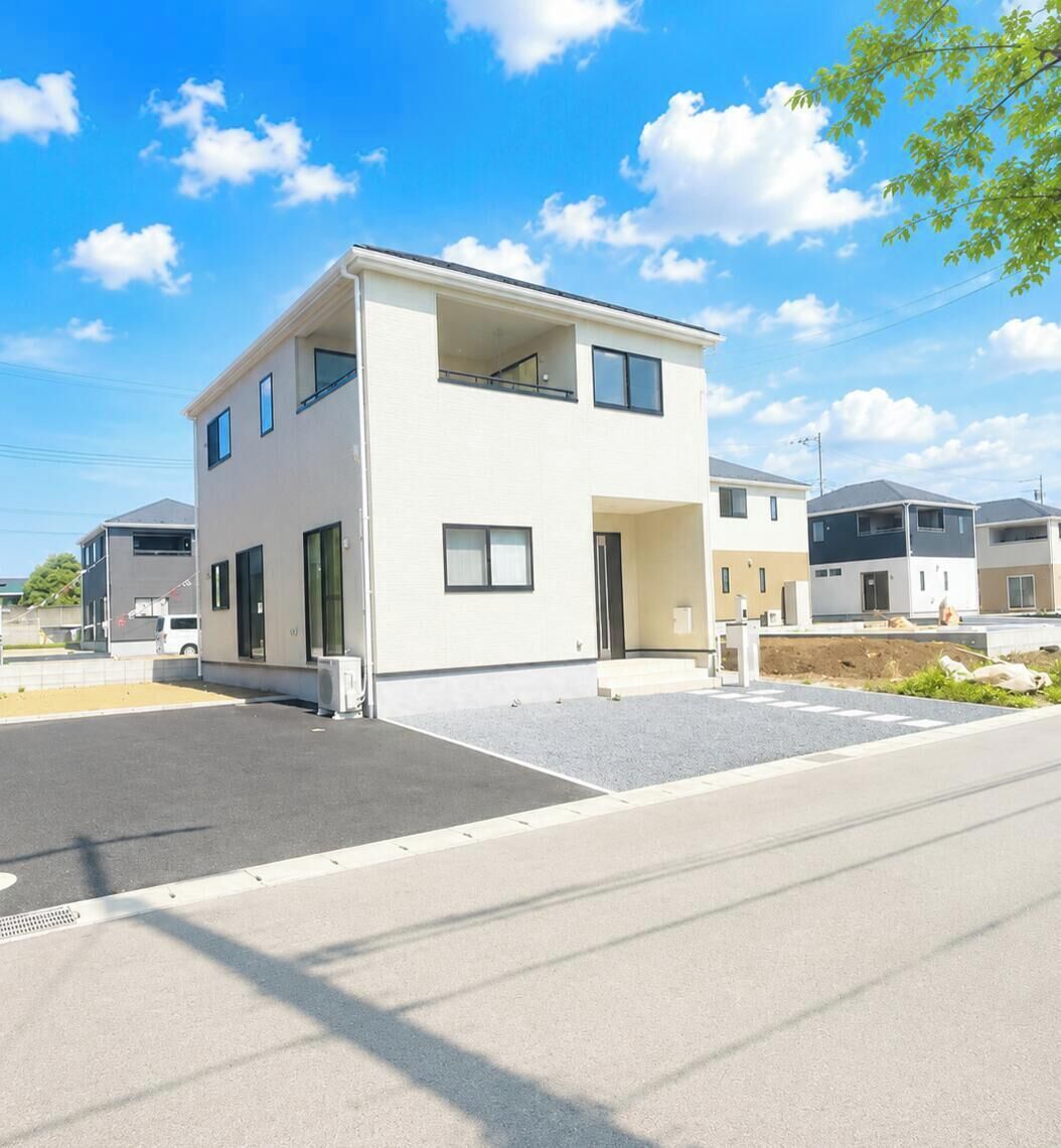 Un immeuble résidentiel moderne à deux étages, doté d’un toit plat, de grandes fenêtres et d’une allée.