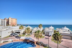 A resort with a swimming pool, palm trees, and a view of the ocean. - La Buena Vida: The Good Life at Las Palmas, Pool, Jacuzzi & Beach Access (Puerto Peñasco)