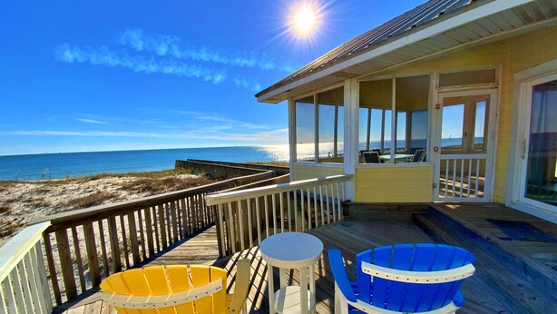 A wooden deck with two chairs and a table overlooking the beach. - Beachfront, Pools, Pickleball, in Morgantown (Gulf Shores)