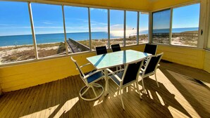 A sunlit room with a view of the beach and ocean through large windows. - Beachfront, Pools, Pickleball, in Morgantown (Gulf Shores)