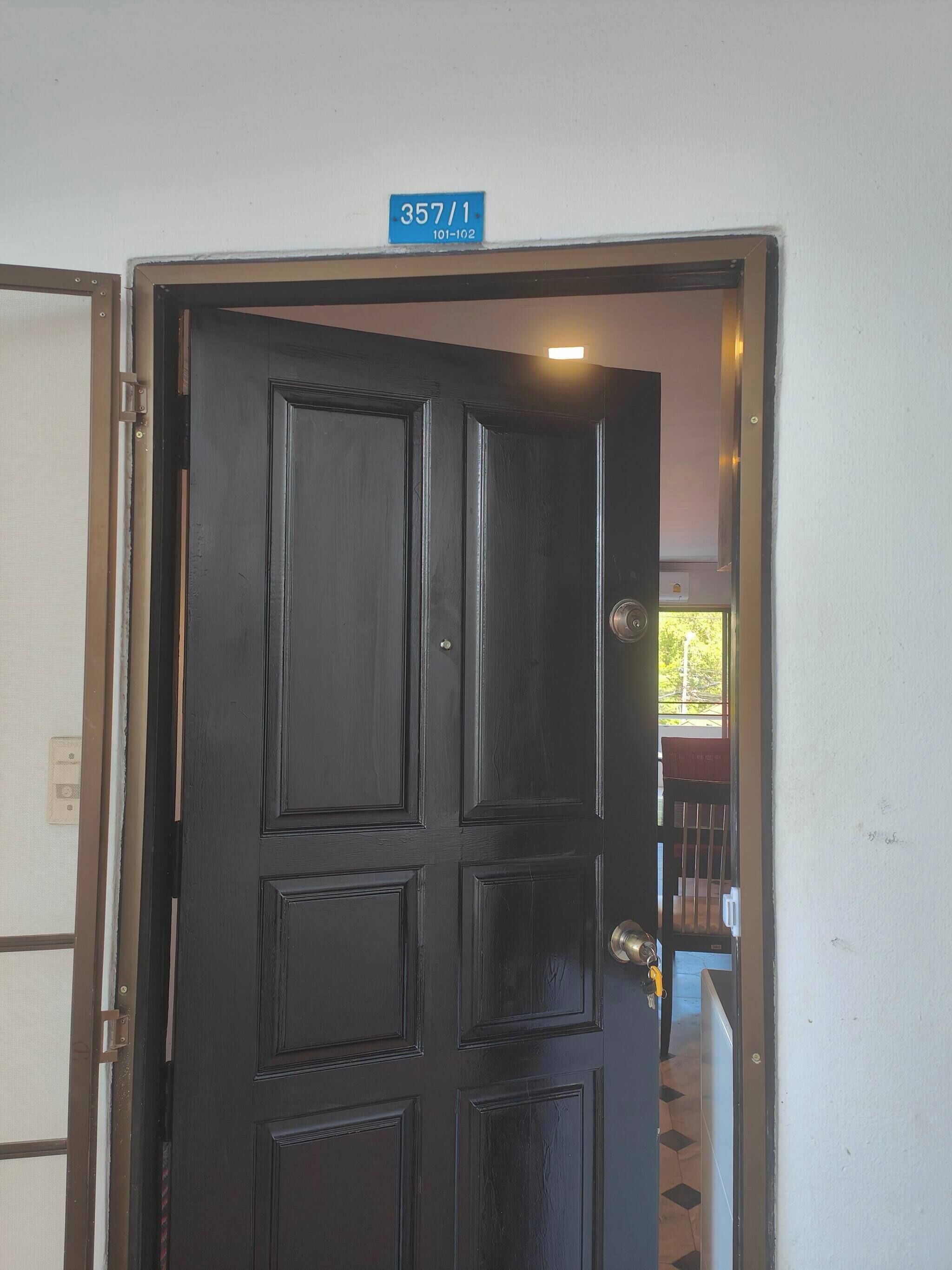 A black door with a blue sign above it.