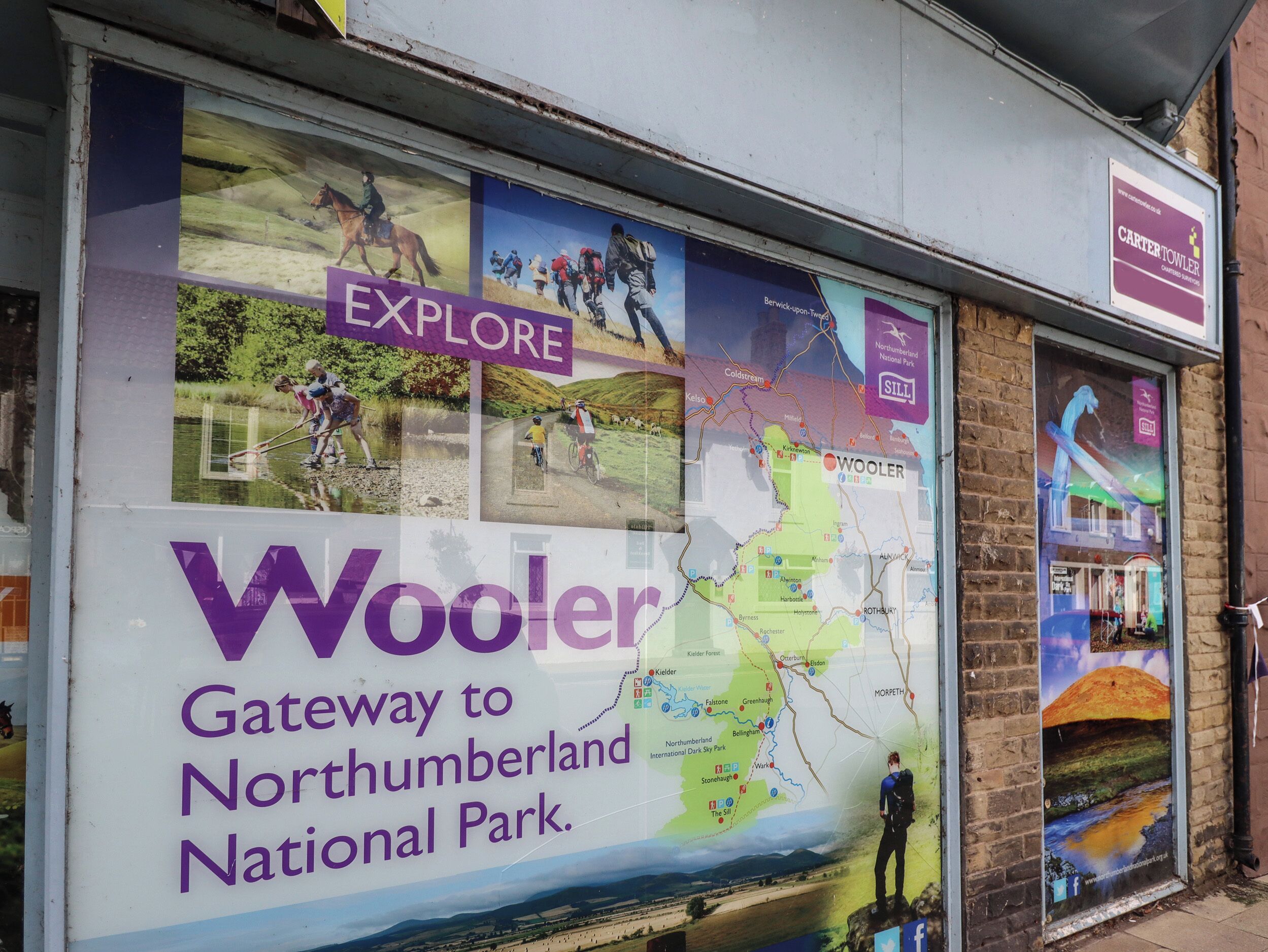 Cartel publicitario de Woolsor, presentado como puerta de acceso al Parque Nacional de Northumberland, con actividades al aire libre y un mapa.