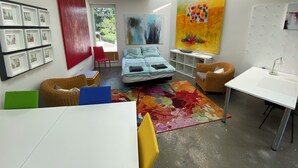 A modern bedroom with a bed, a desk, a chair, and artwork on the walls. - Living in a studio - Living in a Studio (Mülheim an der Ruhr)