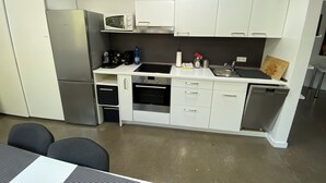 A compact kitchen with white cabinets, a microwave, a coffee maker, and a sink. - Living in a studio - Living in a Studio (Mülheim an der Ruhr)