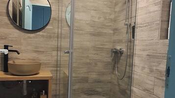 Een douche, een haardroger, pantoffels, handdoeken