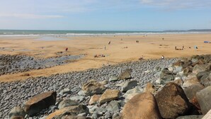 Ein Strand mit felsigem Vordergrund und einer Sandküste.